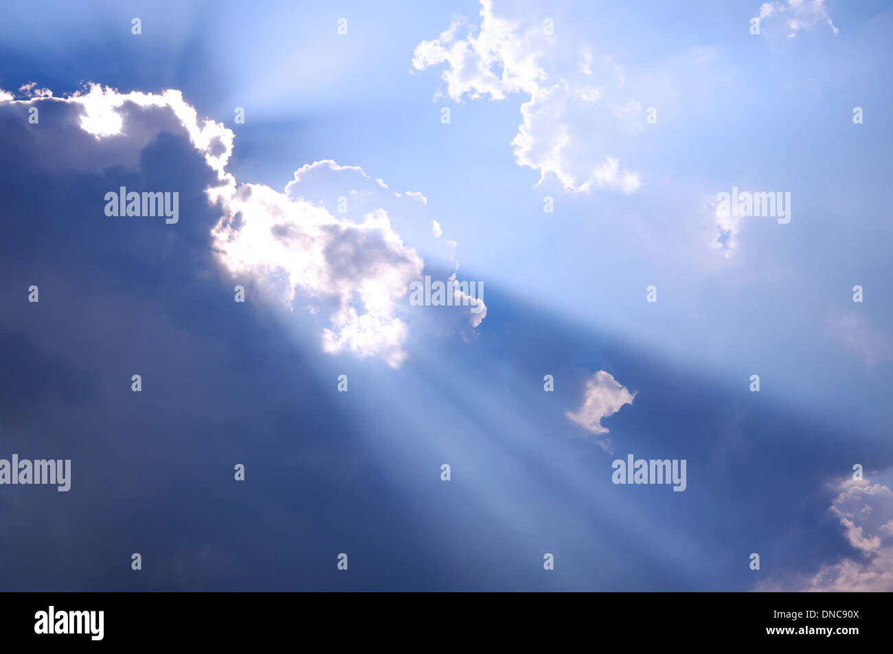 I raggi del sole che passa attraverso le nuvole scure Foto Stock