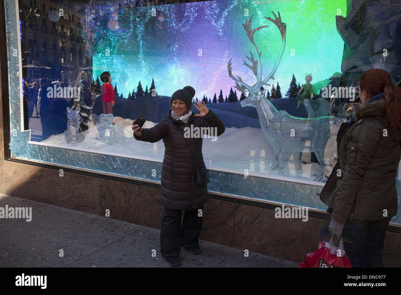 Donna fotografie se stessa nella parte anteriore del Natale windows a Lord & Taylor Dept. Store su 5th Ave, a NYC. Foto Stock