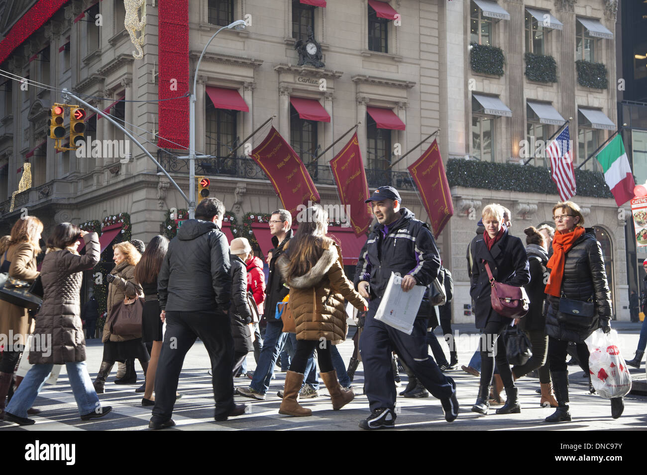 Una folla di gente che acquista lungo la quinta avenue durante la stagione delle vacanze. (Cartier nella sua migliore di Natale in background). Foto Stock