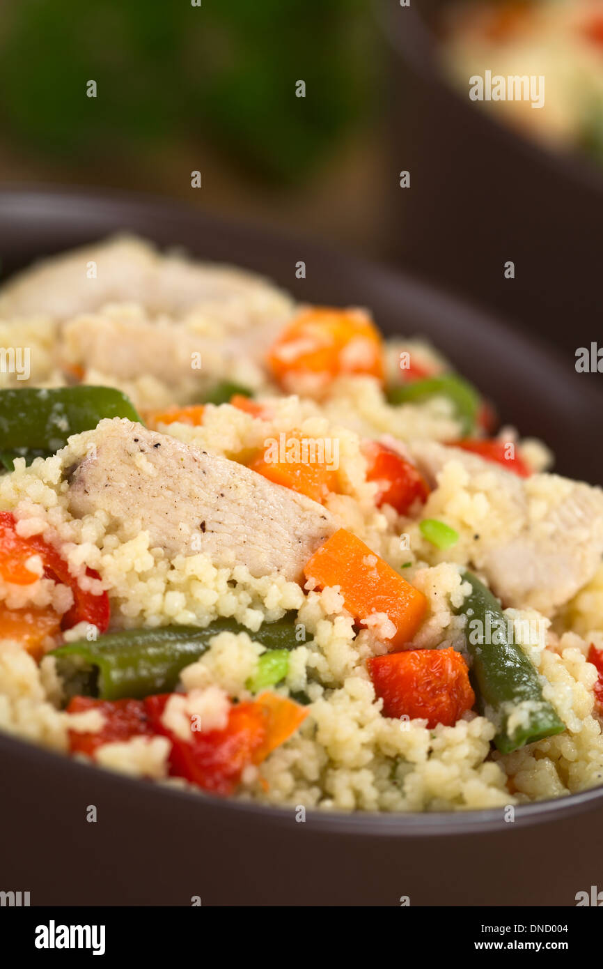 Il cous cous il piatto con il pollo, fagiolo verde, la carota e il peperone rosso servito in una ciotola Foto Stock