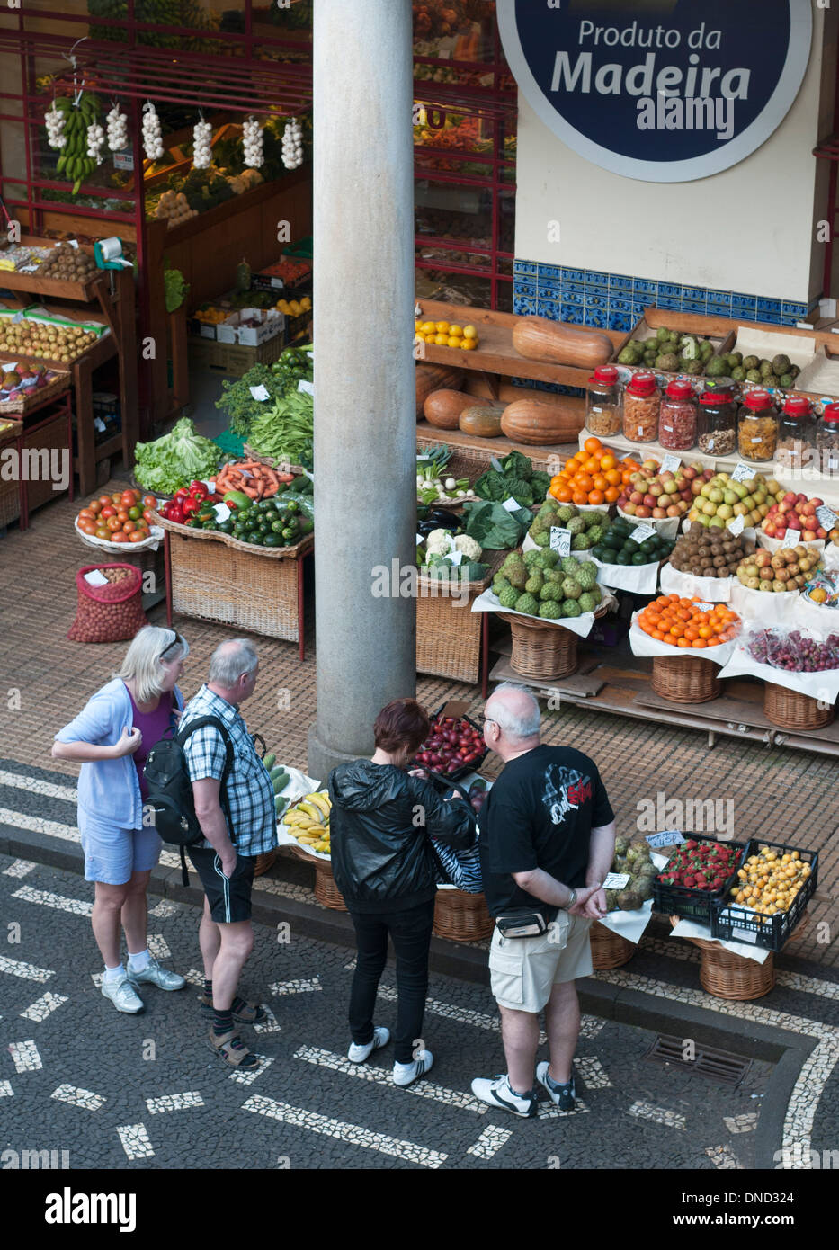 Due coppie in cerca di una frutta/verdura in stallo il Mercado dos Lavradores (mercato agricolo) Funchal, Madeira, Portogallo Foto Stock