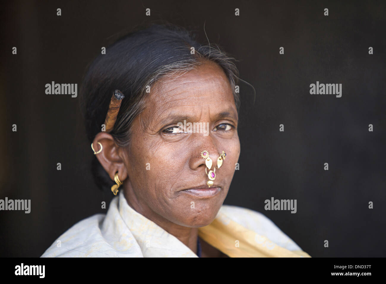 Primo piano di una vecchia donna tribale che fuma bidi, una sigaretta indiana fatta a mano di tabacco o foglie di beedi, Orissa, India. Facce rurali dell'India Foto Stock