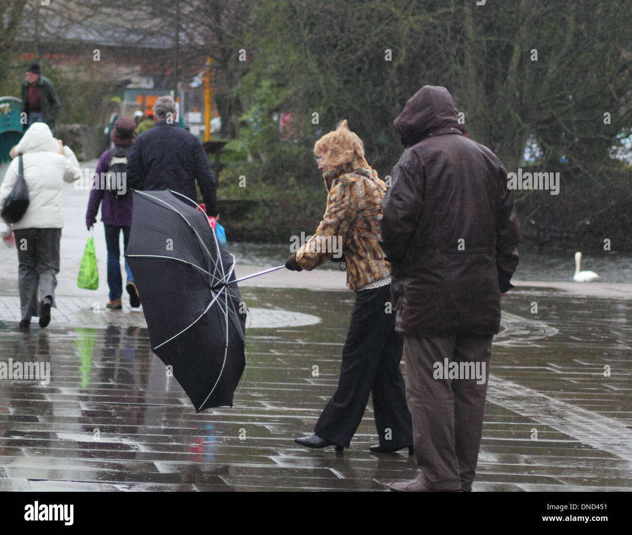 Bakewell, Derbyshire, Regno Unito. Il 23 dicembre 2013. Christmas Shopper battaglia forte pioggia e vento sul giorno di mercato a Bakewell nel cuore del Derbyshire's Peak District. Il Met Office ha emesso gli avvisi di ambra per la pioggia per parti del Regno Unito dal lunedì mattina. Foto Stock