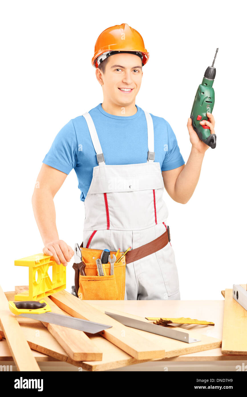 Maschio lavoratore manuale tenendo una mano macchina perforatrice in officina Foto Stock