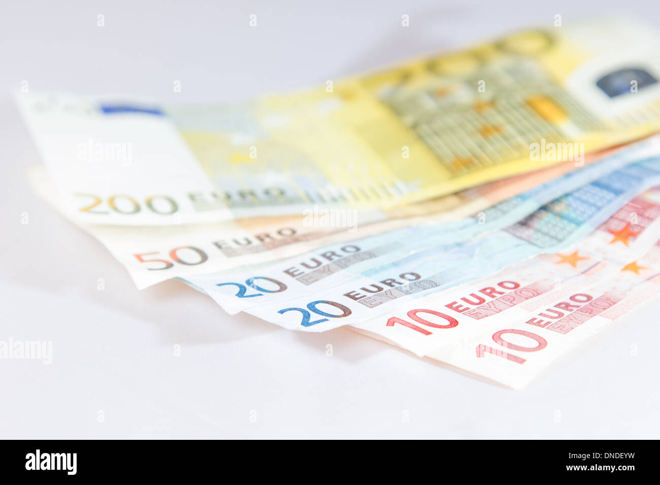 Banconote giacenti su altre note con luce sfondo bianco Foto Stock
