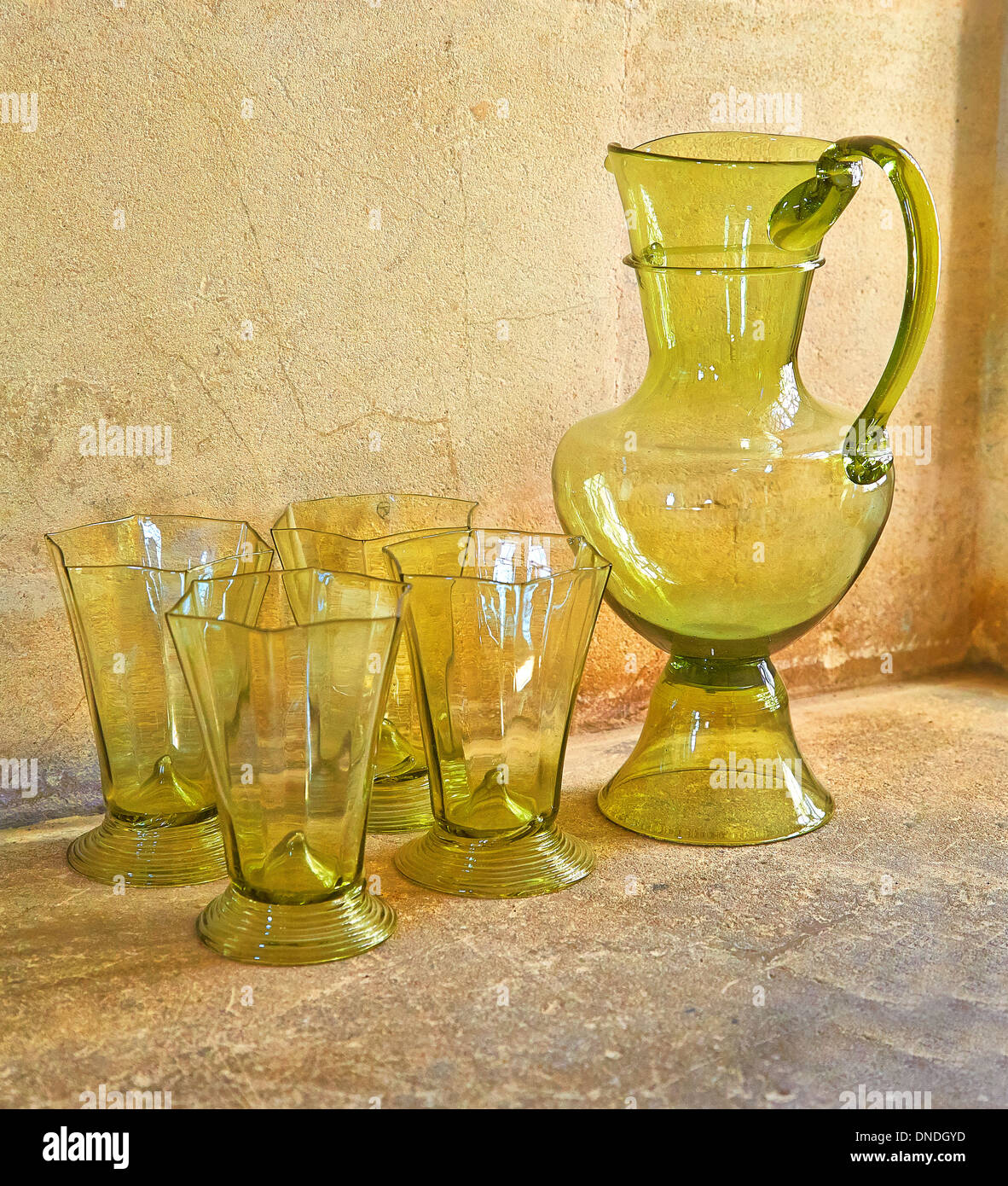 Green caraffa di vetro e quattro nottolini esagonale su una finestra di pietra ripiano Foto Stock