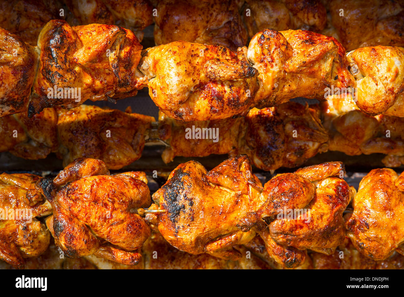 Pollo arrosto in una fila girando alla torrefazione industriale Foto Stock Pollo arrosto in una fila girando alla torrefazione industriale Foto Stock