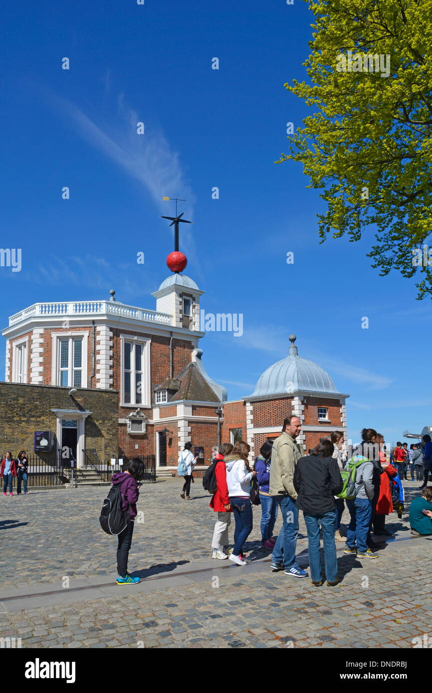 Gruppo di persone si trovano al primo meridiano Greenwich Observatory & Red Historical Time Ball sopra Flamstead House oltre Greenwich Park Londra Inghilterra UK Foto Stock