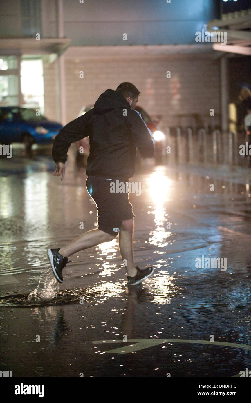 Merthyr Tydfil, Wales, Regno Unito. Il 23 dicembre 2013. Heavy Rain continua senza sosta nel Galles del Sud e last minute gli acquirenti devono negoziare enormi pozzanghere a retail park nella valle città di Merthyr Tydfil. Credito: Graham M. Lawrenc/Alamy Live News. Foto Stock