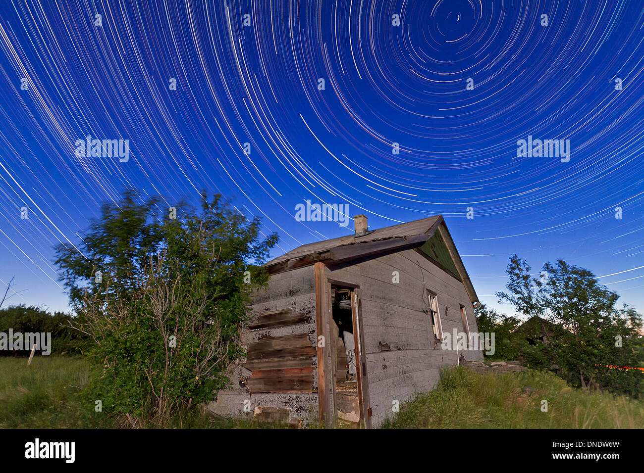 Stella circumpolare sentieri al di sopra di una vecchia casa colonica in Alberta, Canada. Foto Stock