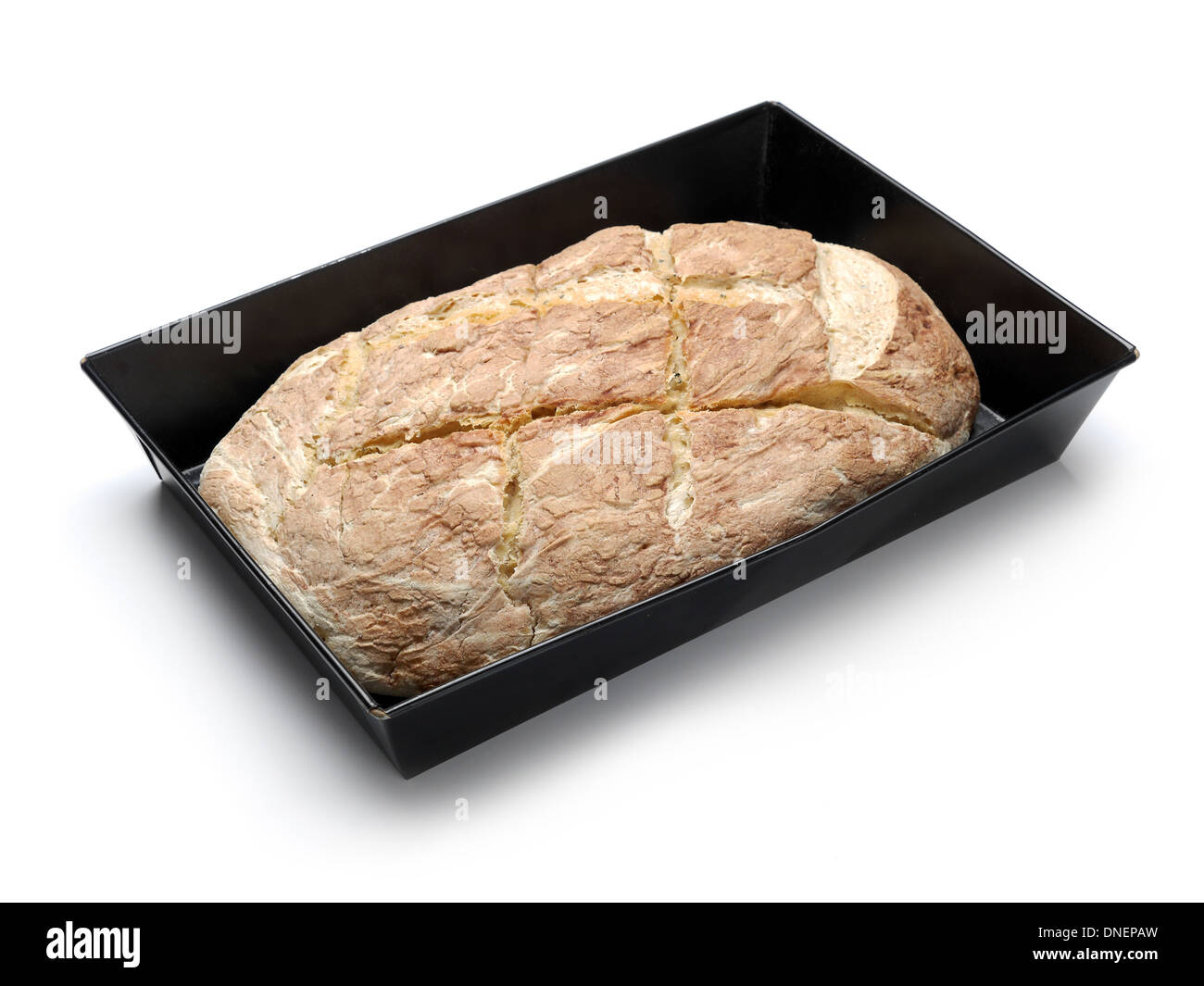 Filone di pane cotto domestico in una teglia da forno su sfondo bianco Foto Stock