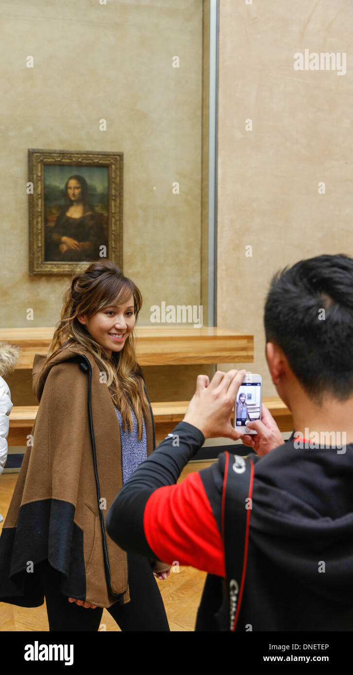L'uomo prendendo foto della donna di fronte Dipinto La Gioconda di Leonardo da Vinci, il museo del Louvre, Parigi, Francia Foto Stock