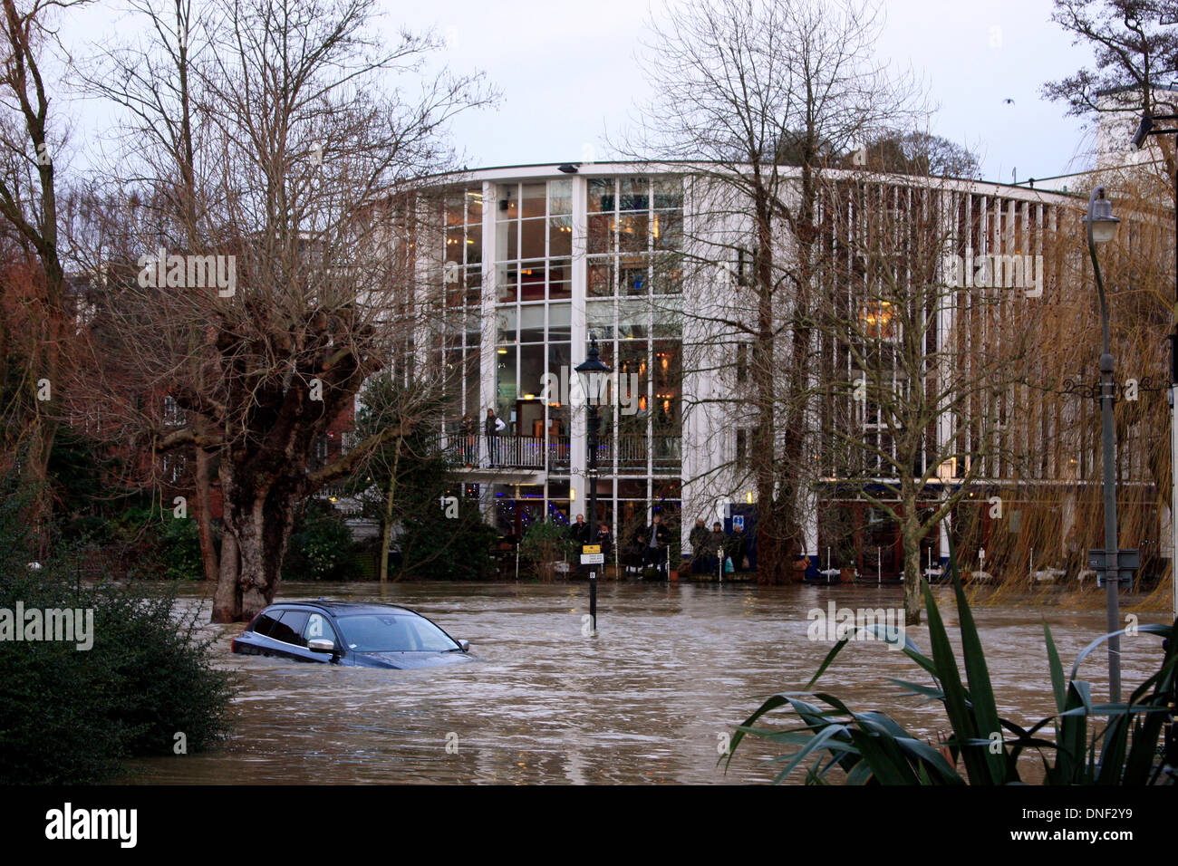 Guildford, Surrey, Regno Unito 24 dicembre 2013. In aumento le acque di esondazione del fiume Wey avvolge un auto in Millmead Parcheggio con la Yvonne Arnaud Theatre in background. Le inondazioni hanno causato da pioggia pesante negli ultimi 24 ore. Credito: Bruce McGowan/Alamy Live News Foto Stock