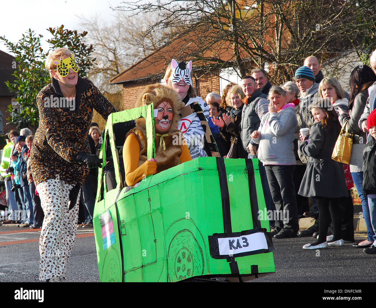 I concorrenti in costume aiutare a spingere un passeggino in una gara di Pagham, West Sussex. Foto Stock I concorrenti in costume aiutare a spingere un passeggino in una gara di Pagham, West Sussex. Foto Stock