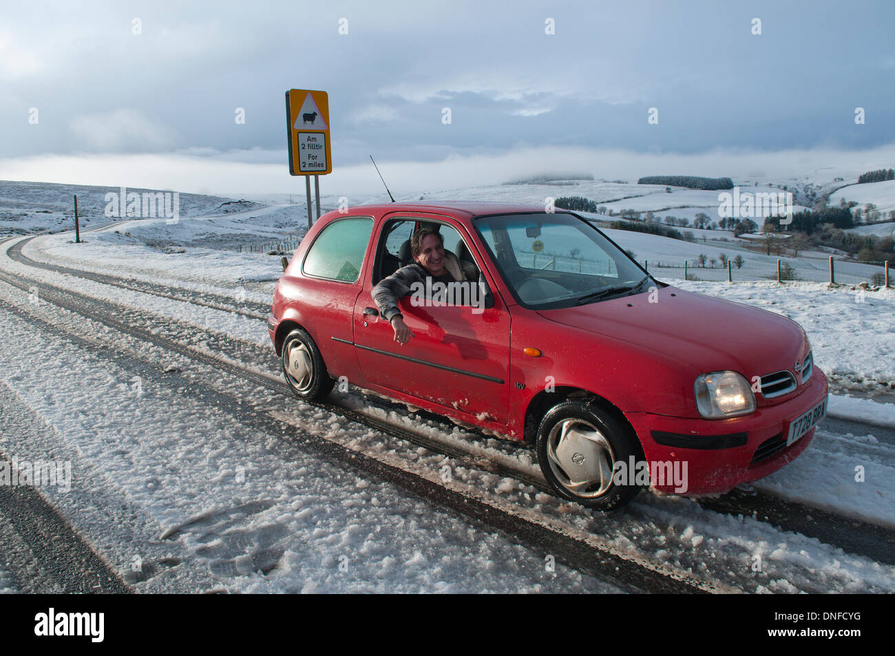 La gamma Epynt, Cambrian Mountains, Powys, Regno Unito. Il 25 dicembre 2013. Driver negoziare la B4520 Brecon road tra Builth Wells e Brecon. Le persone che vivono sulla terra alta in Galles Centrale svegliato da un bianco Natale questa mattina. Credito: Graham M. Lawrence/Alamy Live News. Foto Stock