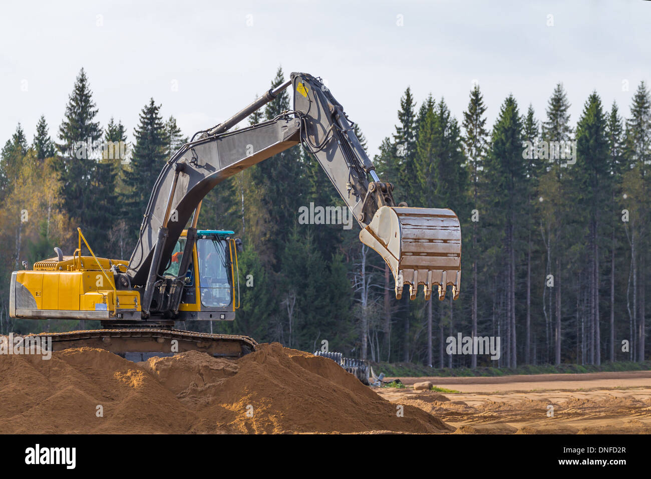 Giallo escavatore di costruzione al lavoro Foto Stock