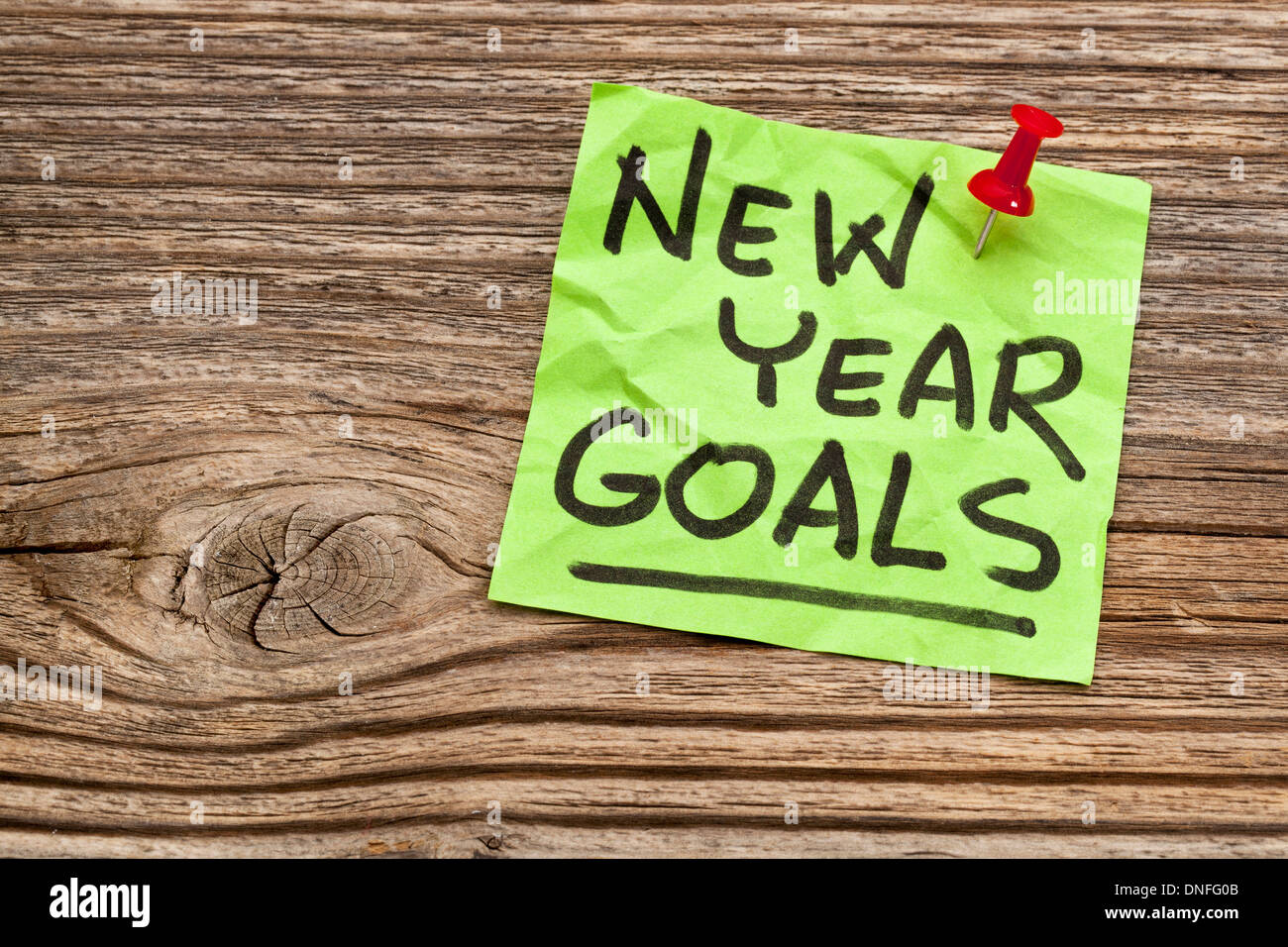 Nuovo anno obiettivi - scrittura su un foglietto adesivo contro il legno zigrinato Foto Stock