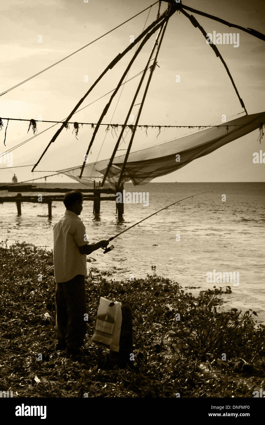 Fisherman impegnativo pesca cinesi trappola, Fort Kochi, Kochi, Kerala, India Foto Stock