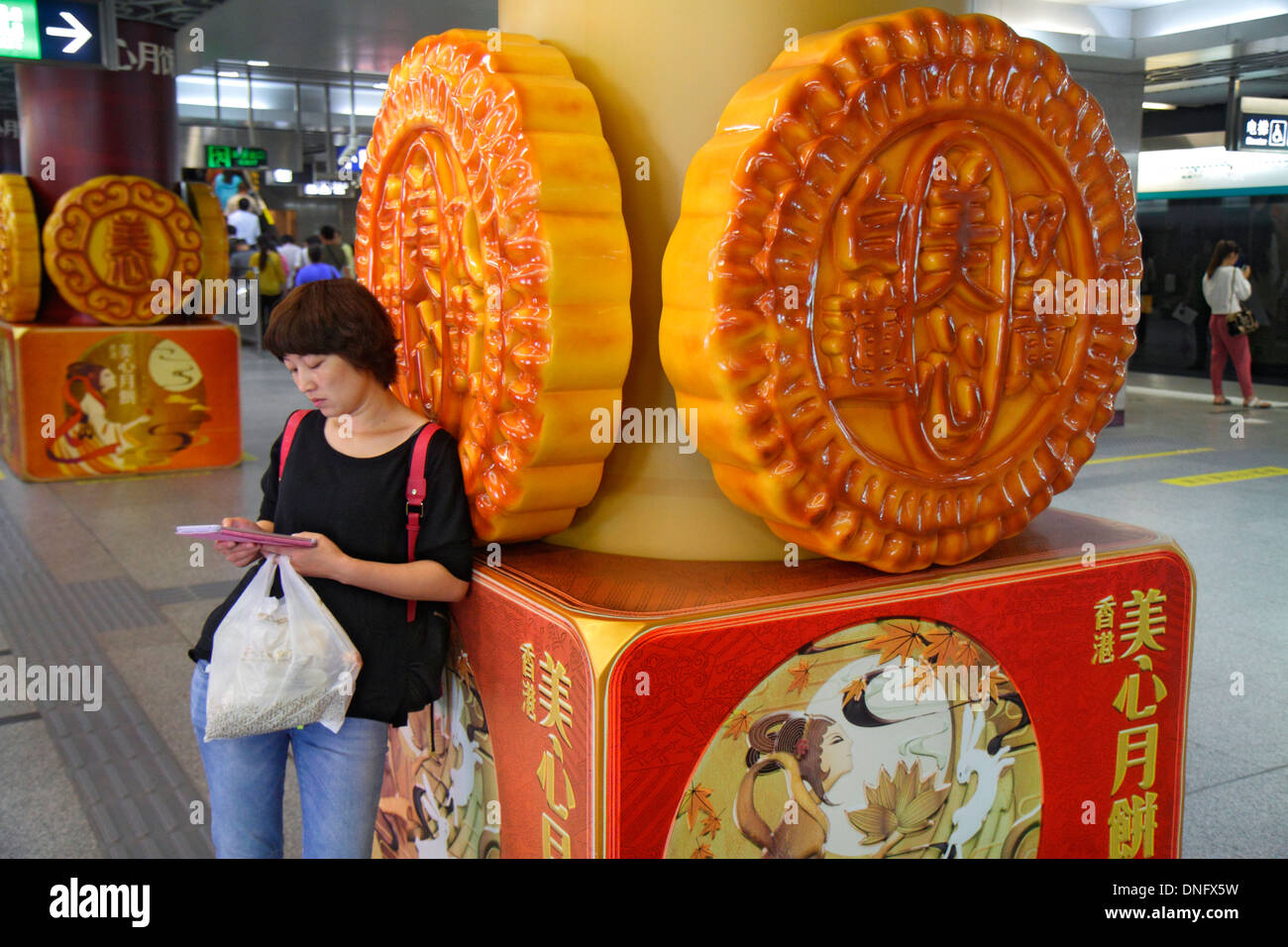 Pechino Cina, cinese, stazione della metropolitana Xidan, linea 1 4, arte, scultura, piattaforma, asiatico adulto, adulti, donna donna donne, utilizzando iPad, tablet, caratteri cinesi Foto Stock