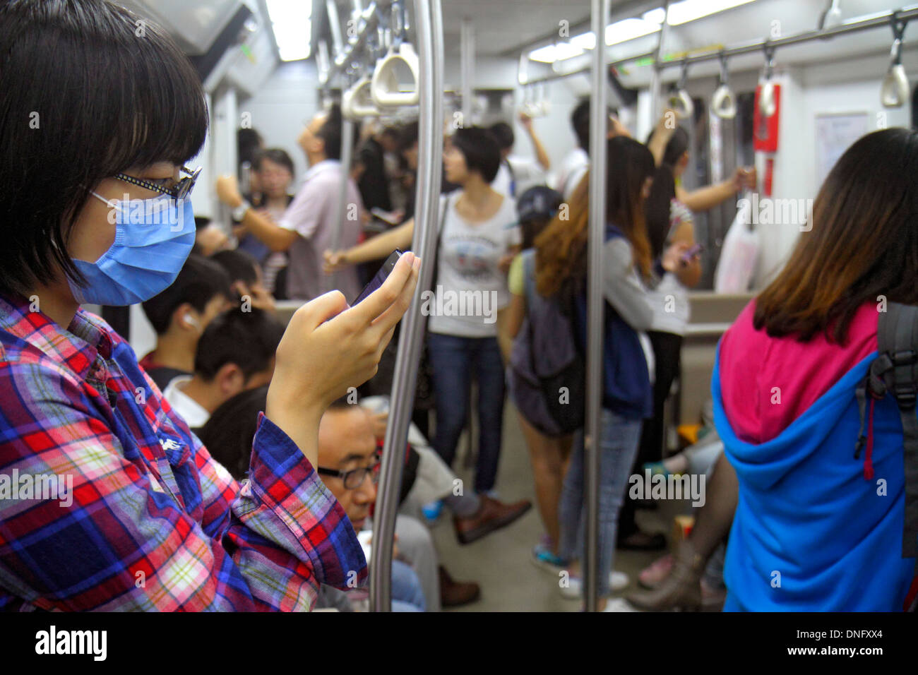 Pechino Cina, cinese, stazione della metropolitana Dongsi, linea 5 6, cabina del treno, adulti asiatici, donne donne, passeggeri passeggeri motociclisti, rider, smartph Foto Stock