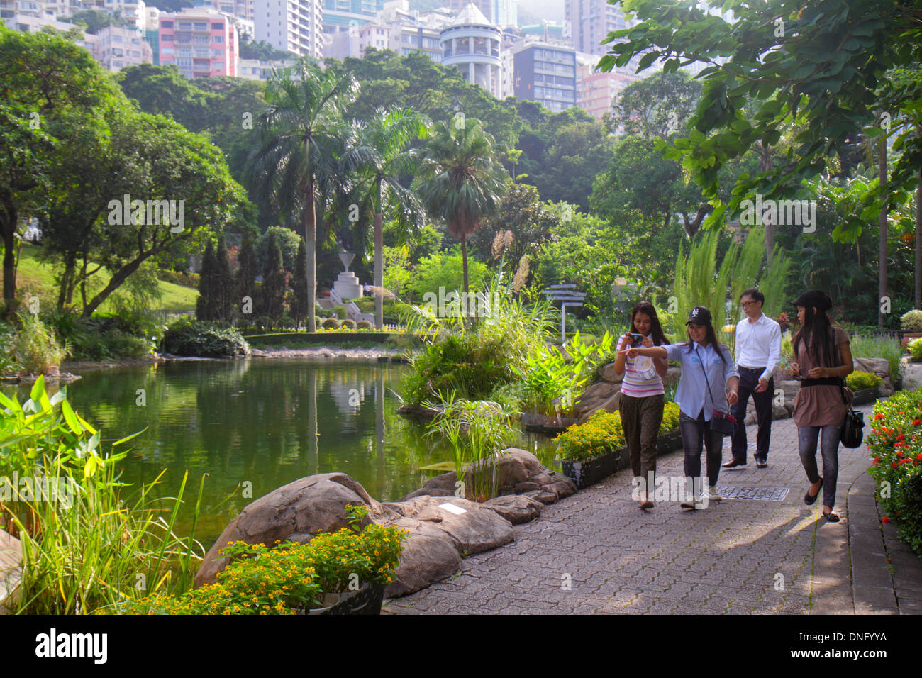 Hong Kong Cina,Hong Kong,Asia,cinese,orientale,isola,centrale,Hong Kong Park,paesaggio,alberi,stagno,adulti asiatici,donne donne donne,amici,skyline della città Foto Stock