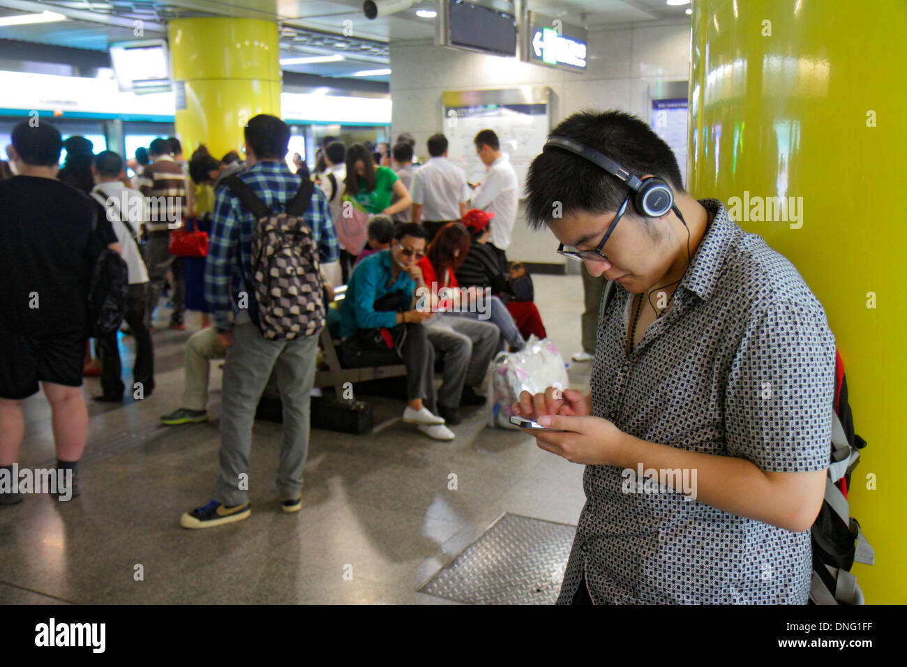 Pechino Cina, cinese, Dongzhimen stazione della metropolitana, passeggeri passeggeri motociclisti, rider, uomo asiatico uomini maschio, linea 2, piattaforma, in attesa, smartphone cellulare pho Foto Stock