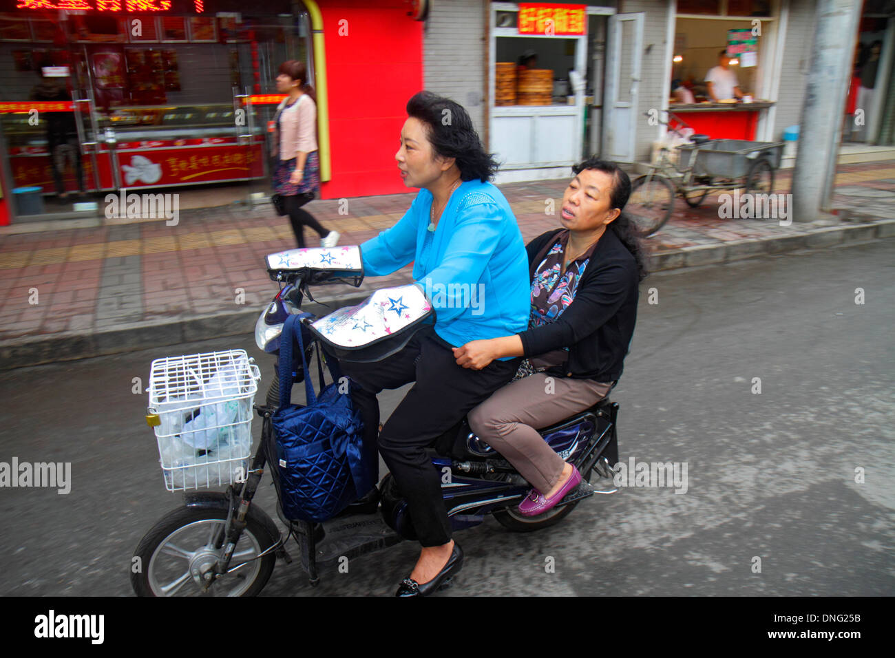Pechino Cina,Asia,cinese,orientale,Xicheng,strada,asiatici asiatici,adulti,donna donna donna donna donna donna donna donna donna donna donna donna donna, amici,scooter elettrico scooter, equitazione, visitatori Foto Stock