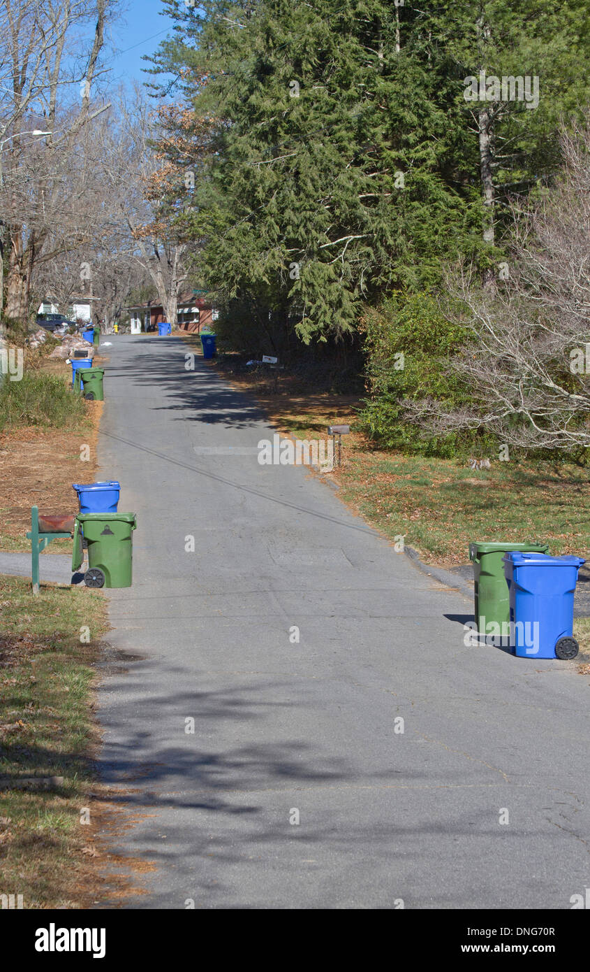 Un quartiere street foderato con cestino di riciclaggio e contenitori pronti per il ritiro Foto Stock