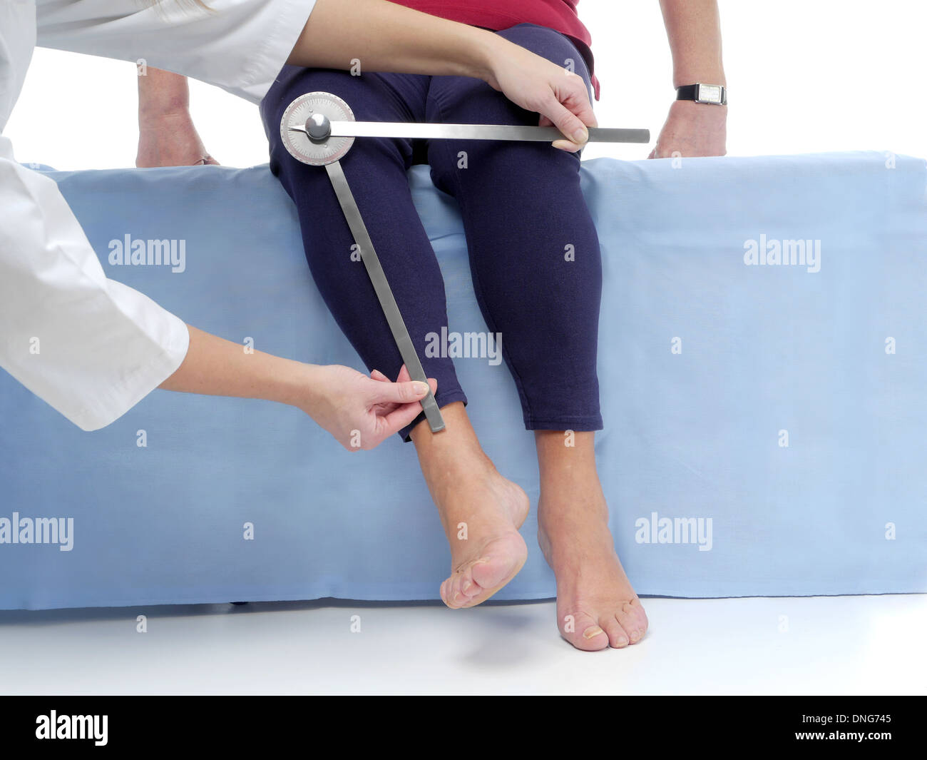Fisioterapista attiva di misura il raggio di movimento dei pazienti anziani dell'arto inferiore utilizzando goniometro manuale Foto Stock