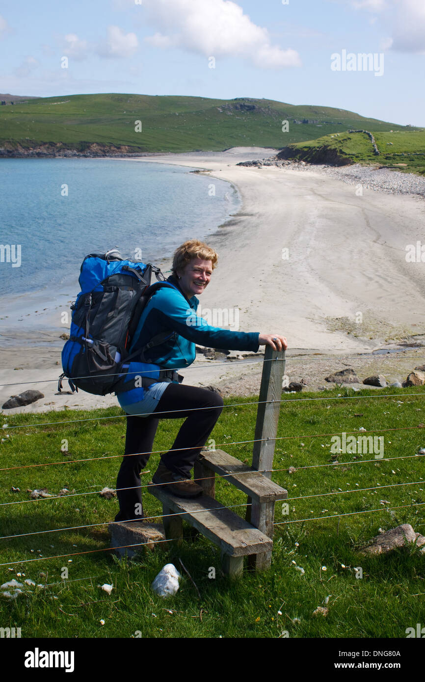 Una donna con lo zaino in spalla in spiaggia a Lund, Unst, Isole Shetland Foto Stock
