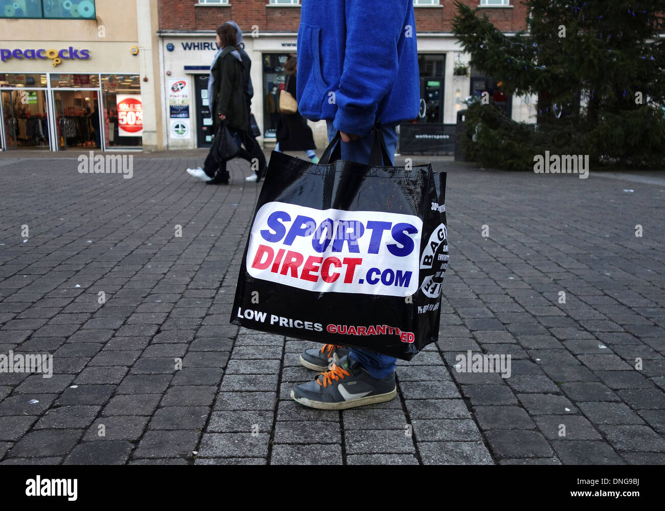 Un cliente che porta con sé una diretta sport shopping bag Foto Stock