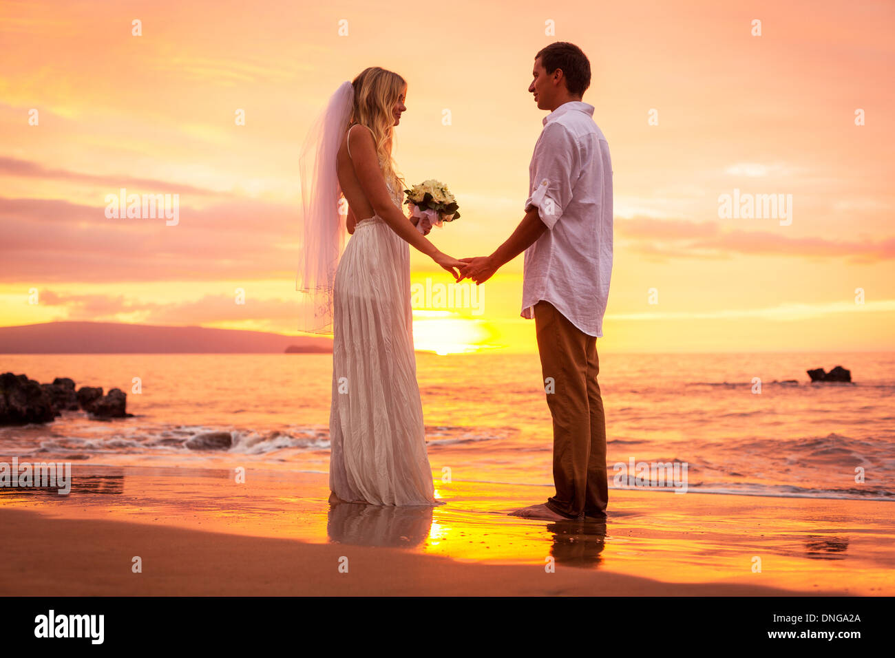Appena una coppia sposata sulla spiaggia tropicale al tramonto, intimo momento amorevole a Wedding Foto Stock