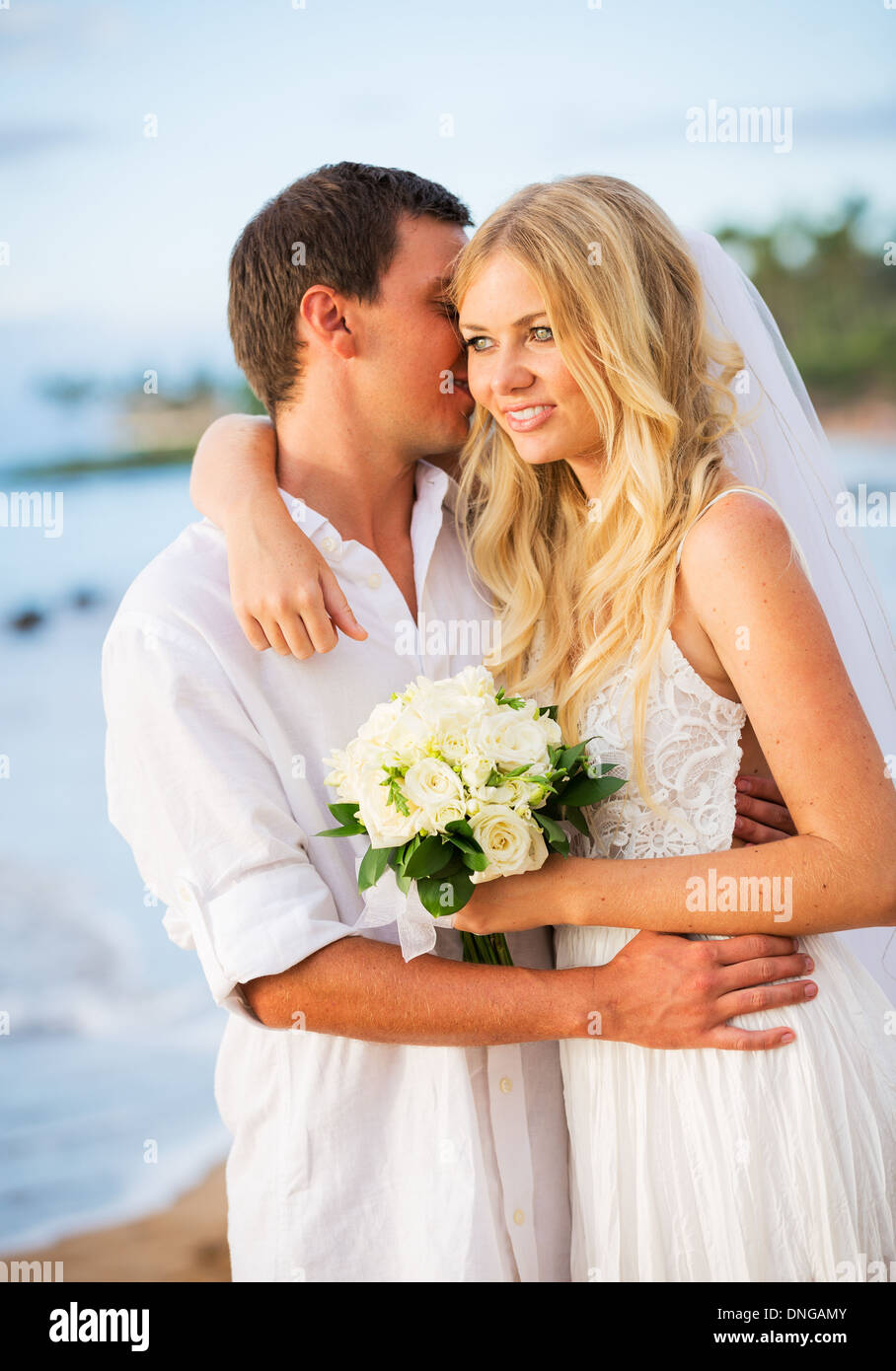Appena una coppia sposata abbracciando sulla spiaggia, Hawaii matrimonio sulla spiaggia Foto Stock