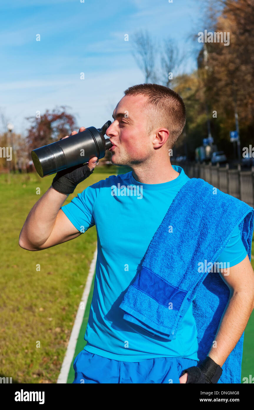 Giovane uomo acqua potabile dopo allenamento Foto Stock