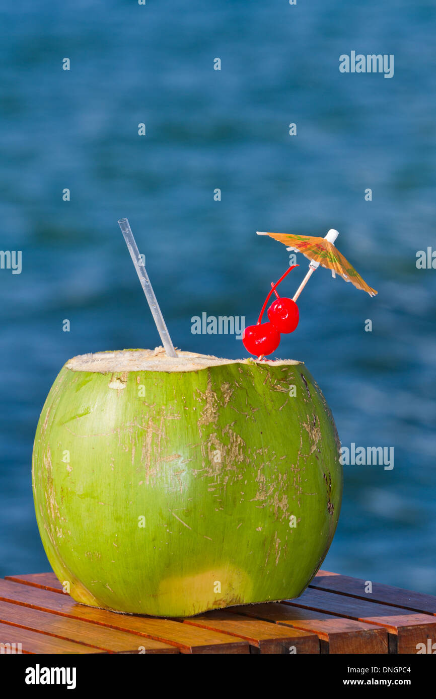 Il cocco drink servito in una noce di cocco verde con il rum e succhi di  frutta è servita sulla spiaggia del Belize Foto stock - Alamy