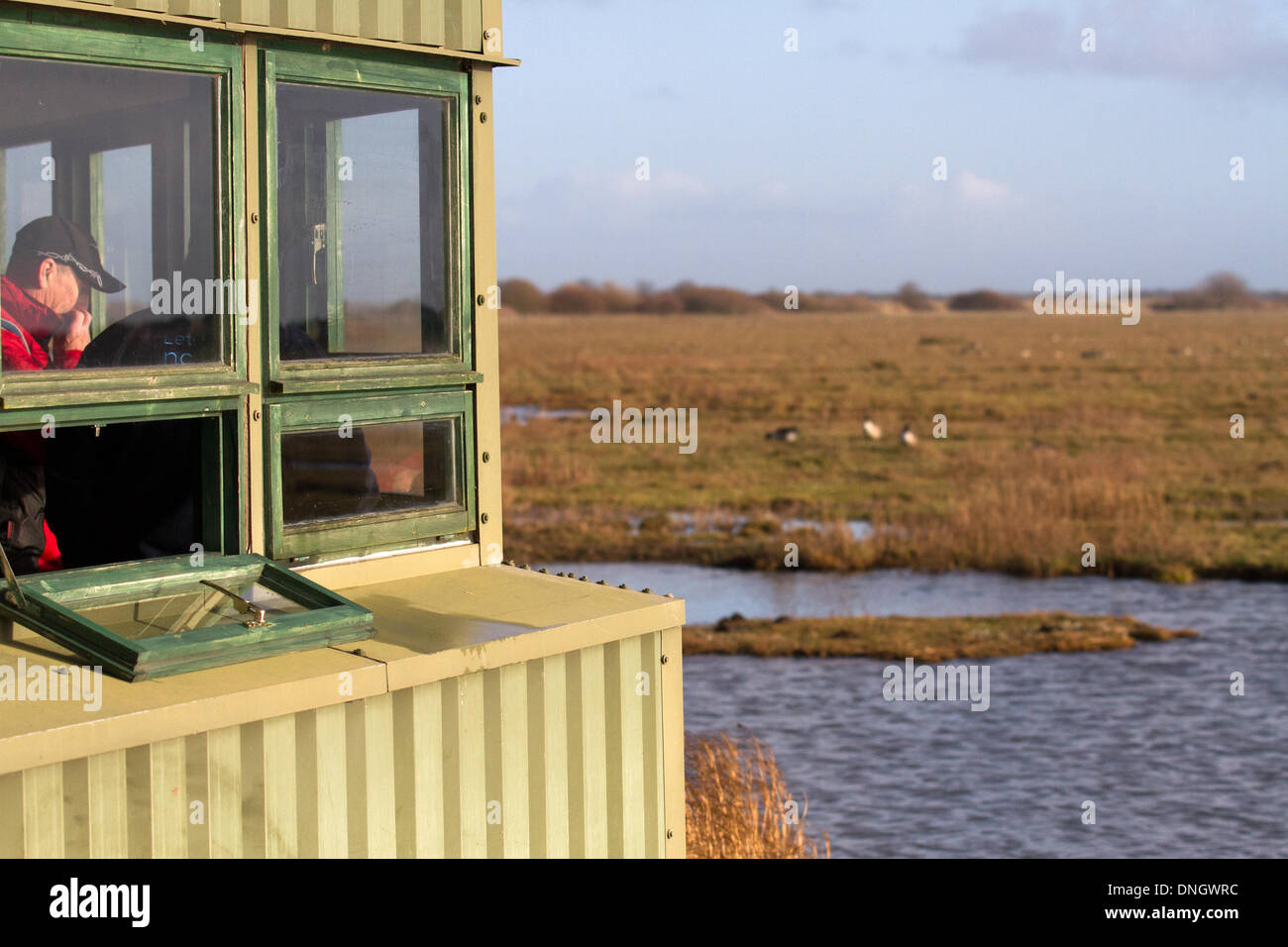 Birdwatching, birdwatching, osservazione della fauna selvatica binocoli, scopi, ottica, cavalletti. Birdwatchers che controlla le specie migratorie di uccelli nella riserva di Marshside RSPB. Secondo alcuni report, gli uccelli acquatici hanno spostato le loro zone di inverno verso nord-est a causa delle mutevoli temperature invernali in Europa. Un cambiamento che può avere implicazioni per la loro conservazione, perché gli uccelli stanno facendo meno uso delle riserve che sono state designate per proteggerli. Molti usano le riserve WWT del Lancashire quasi come stazione di servizio per riposare e rifornire di carburante per alcune settimane prima di continuare il loro viaggio verso sud. Foto Stock