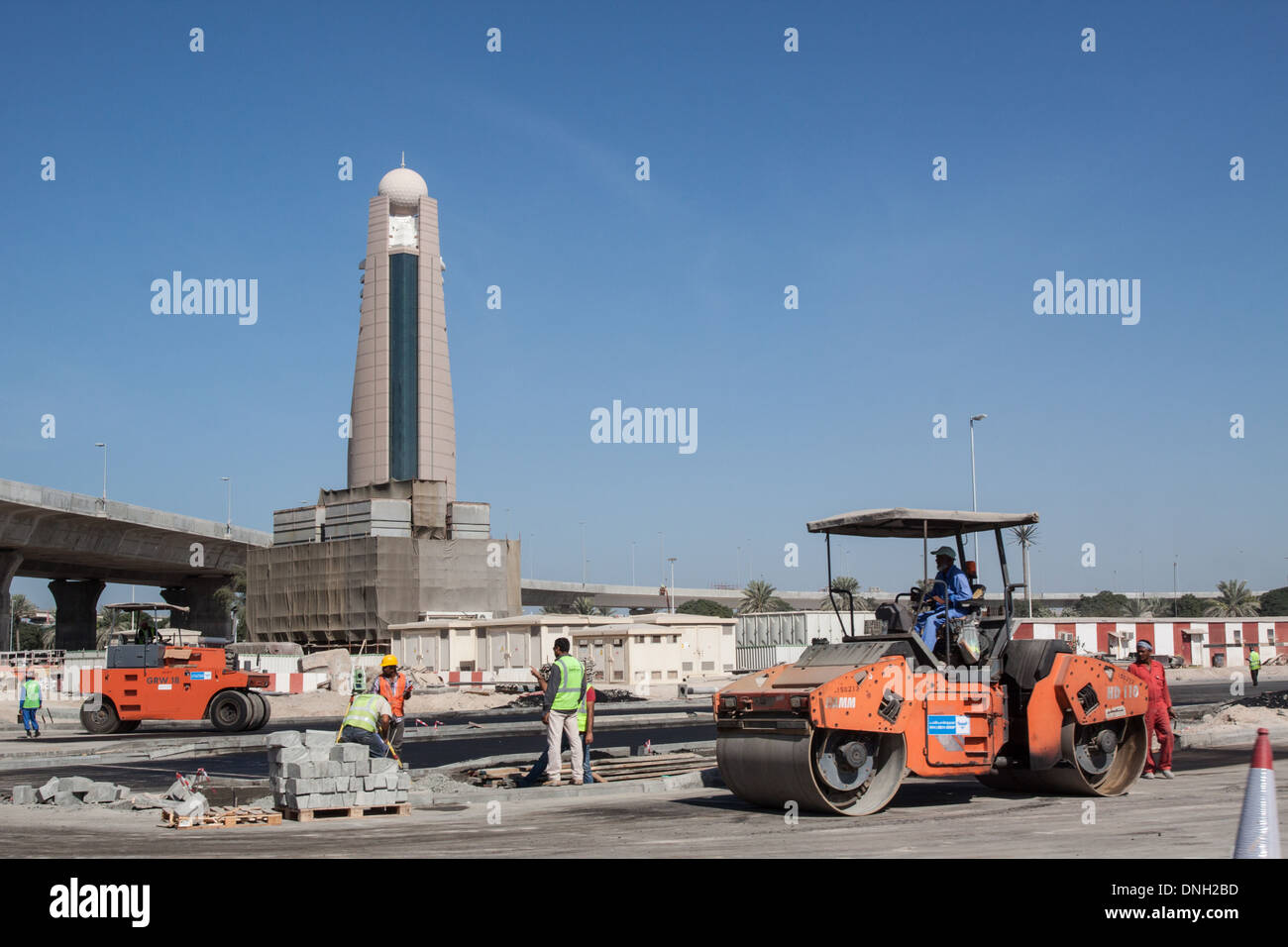 Opere Pubbliche di veicoli e i lavoratori immigrati a un'autostrada sito in costruzione, centro finanziario, DUBAI, Emirati arabi uniti, MEDIO ORIENTE Foto Stock