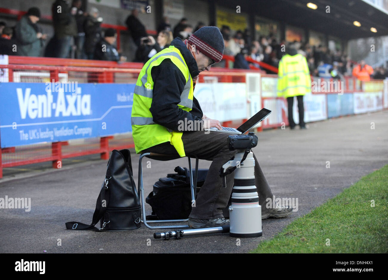 Fotografo sportivo che invia immagini dal lato del campo di calcio utilizzando un computer portatile - solo per uso editoriale. Nessuna merchandising. Per le immagini di calcio si applicano restrizioni fa e Premier League inc. Nessun utilizzo di Internet/mobile senza licenza FAPL - per i dettagli contattare Football Dataco Foto Stock