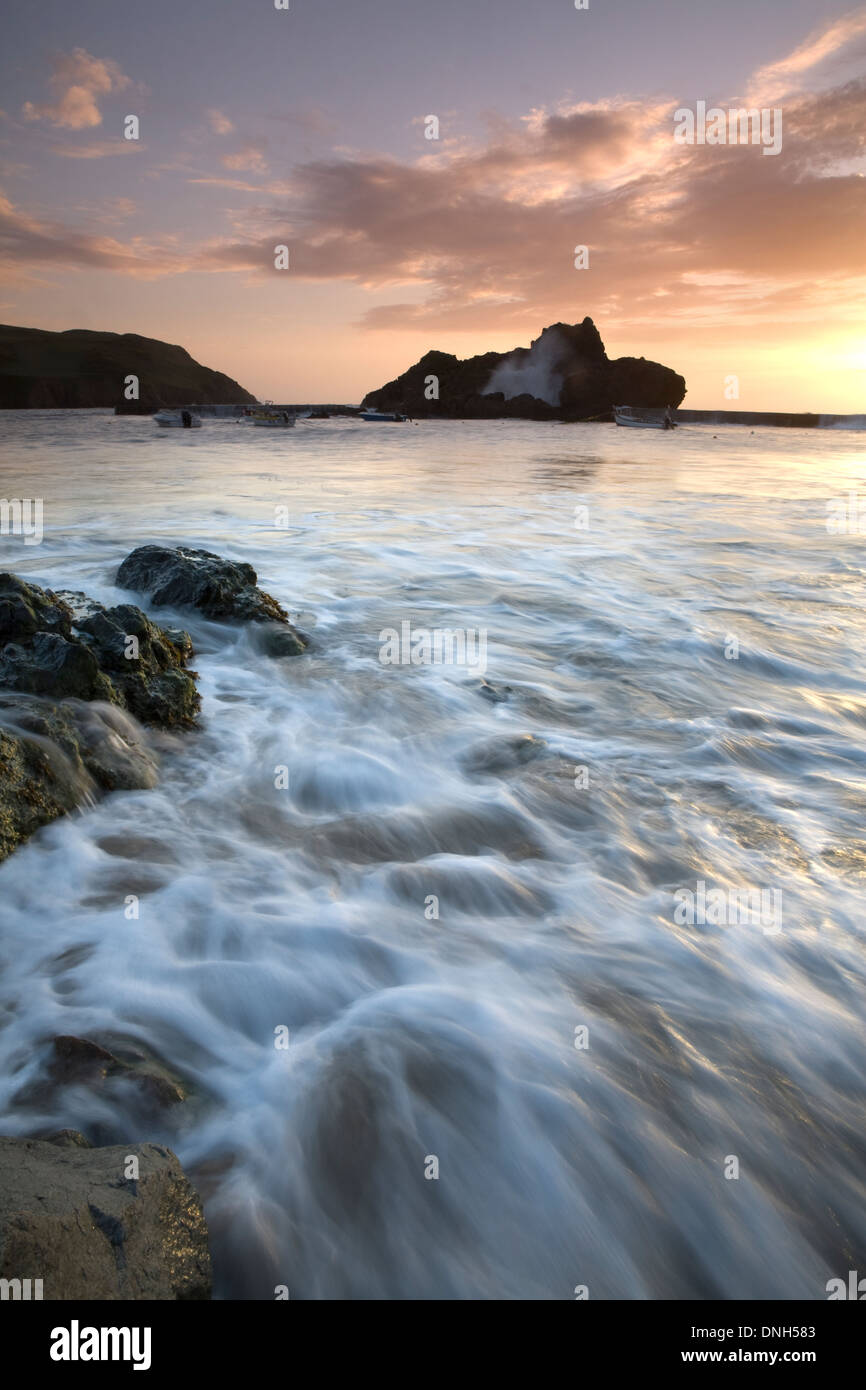 La marea si precipita in attraverso il porto a Hope Cove, Devon, Inghilterra, al tramonto. Foto Stock