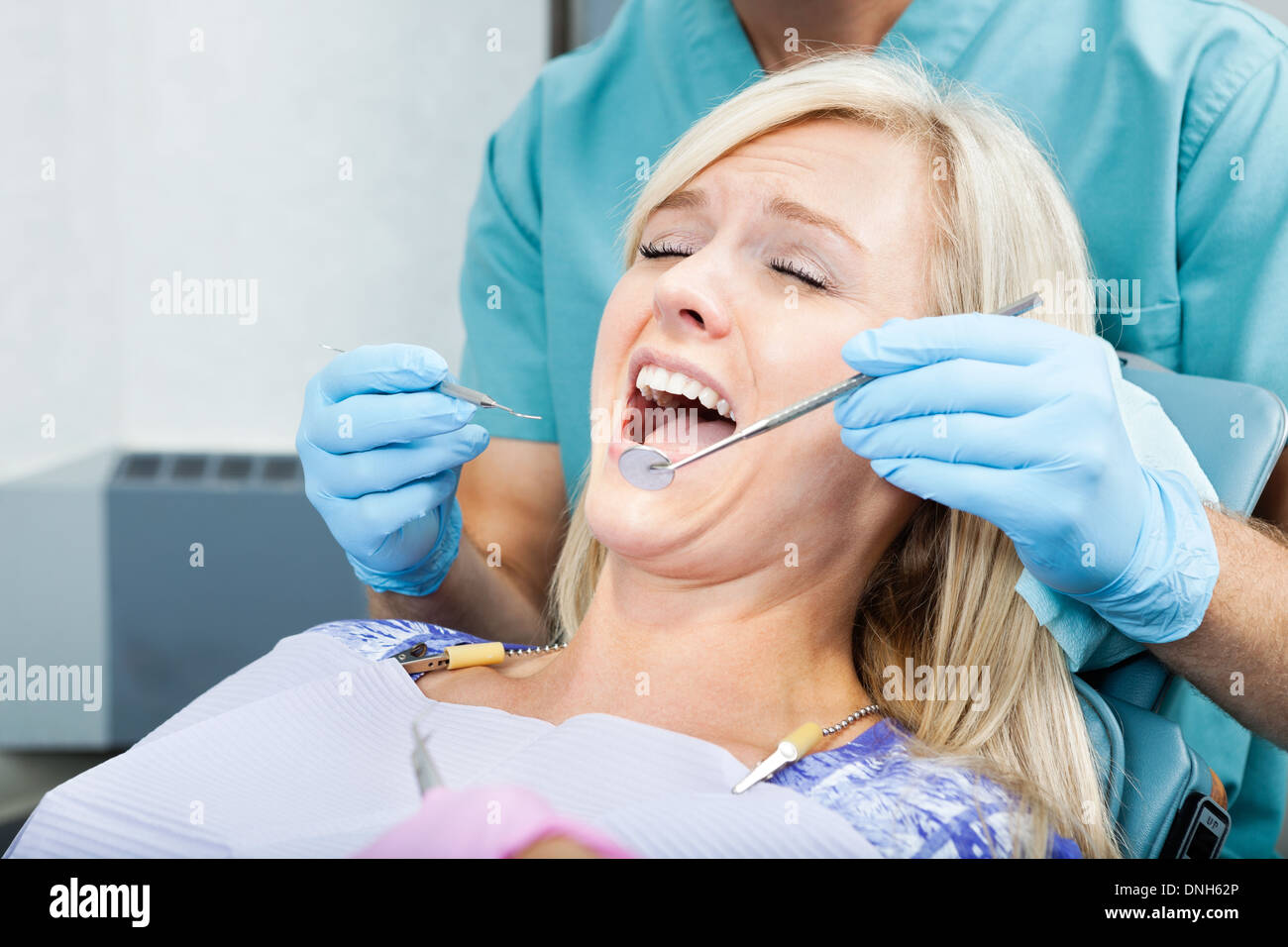 Dentista il trattamento di un paziente di sesso femminile in cliniche Foto Stock