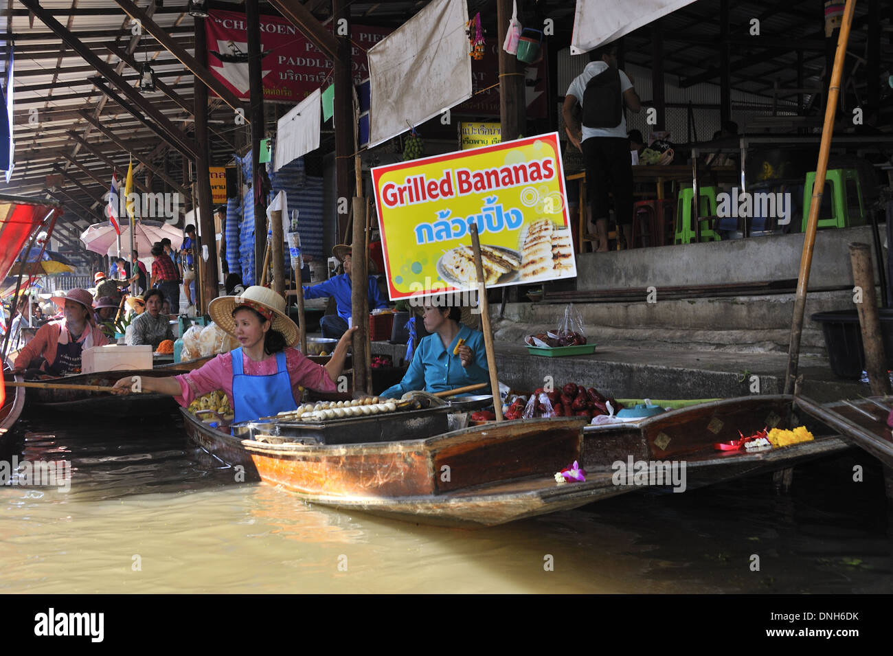 Mercato Galleggiante di Damnoen Saduak. Tradizionali di banane alla griglia per la vendita di barche nel mercato galleggiante. Foto Stock