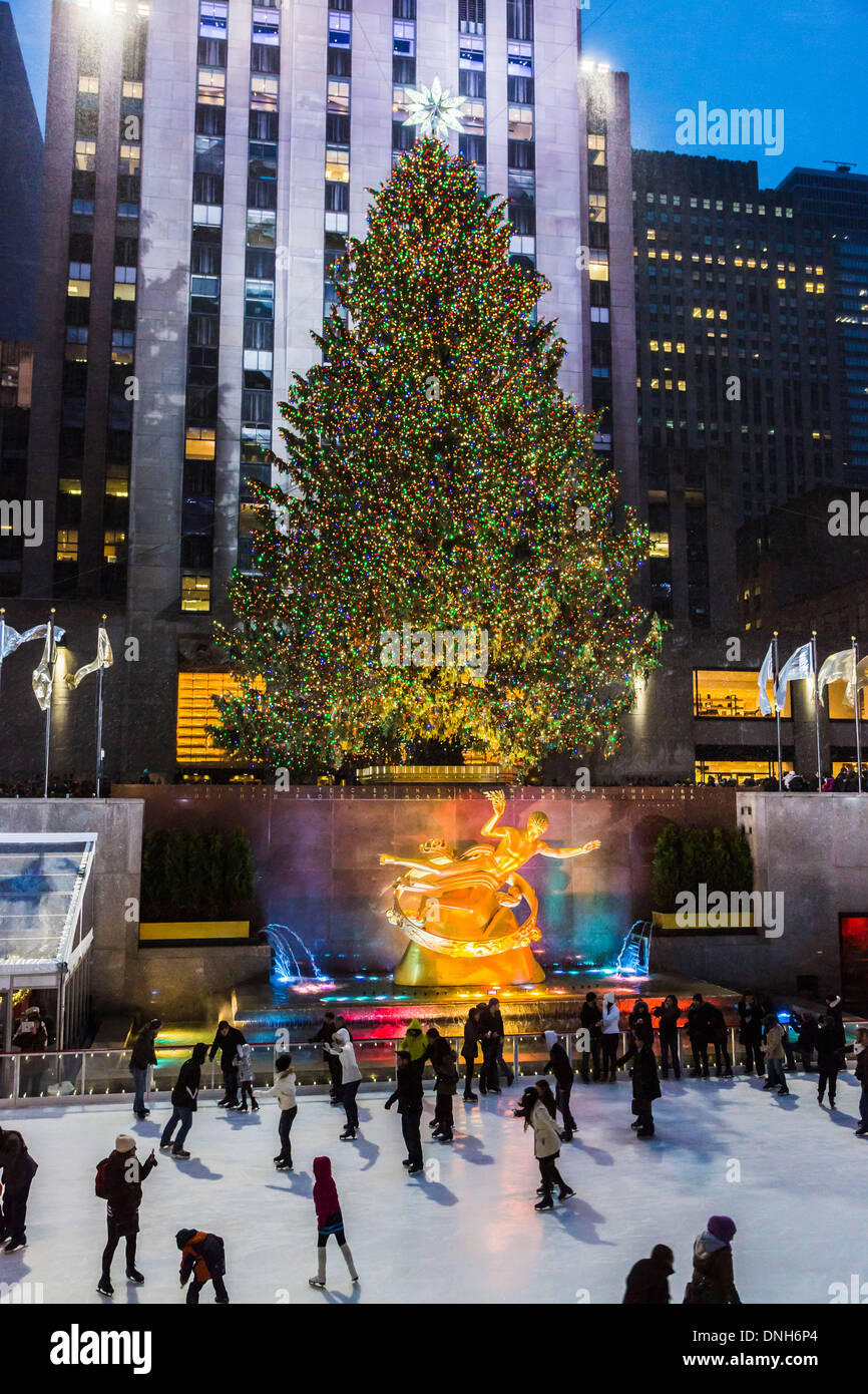 Rockefeller Plaza di New York con i pattinatori godendo di pattinare sulla pista di pattinaggio illuminata con albero di Natale luci, al crepuscolo Foto Stock