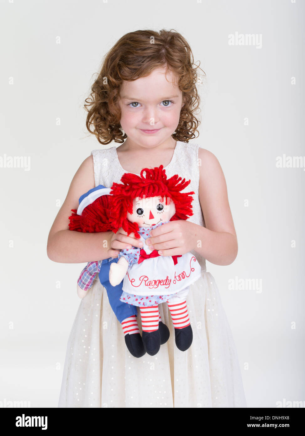 Raggedy Ann e Andy giocattoli per bambini detenuti da giovane ragazza con i capelli rossi. Foto Stock