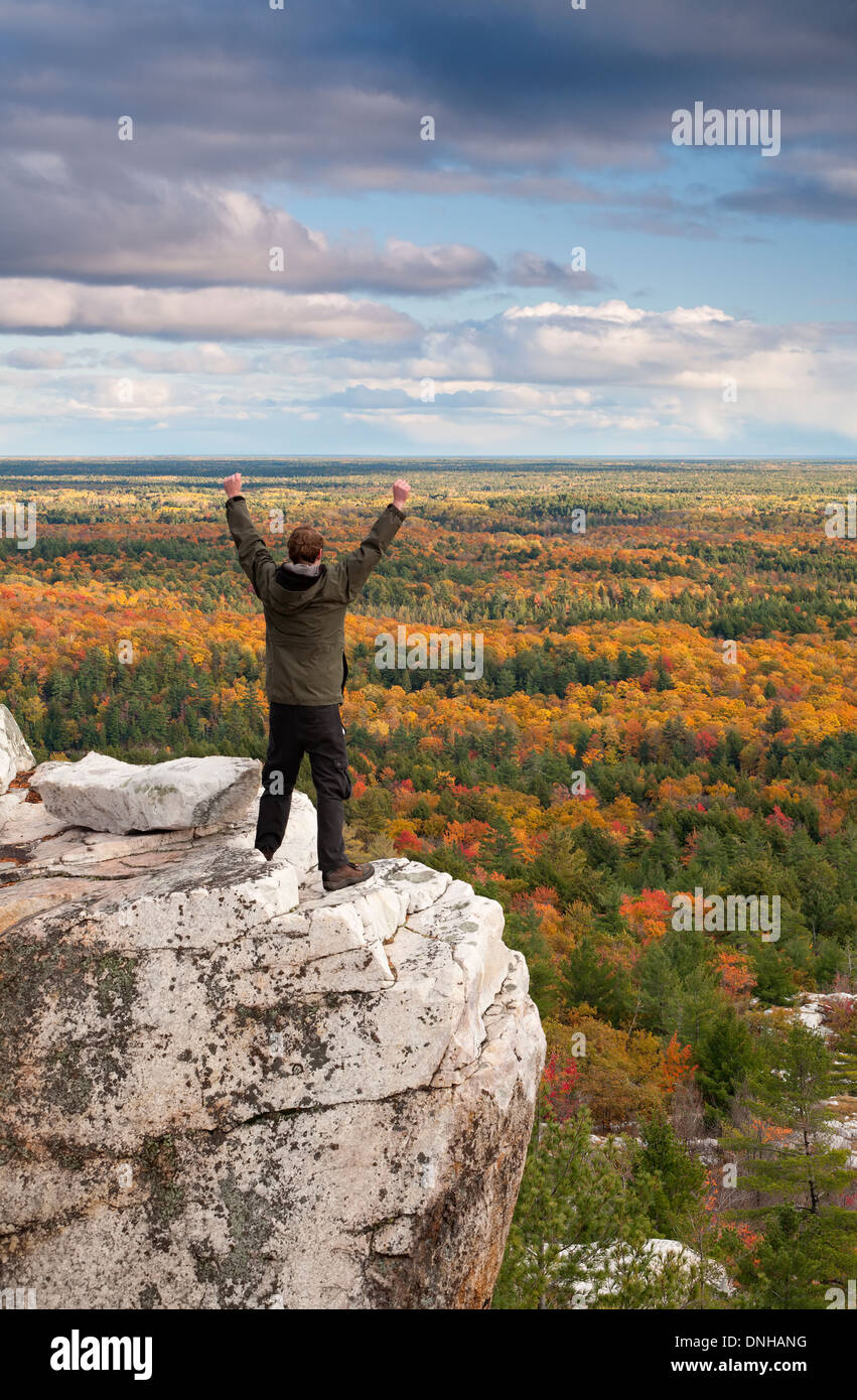 Un escursionista mostra la sua emozione sul bordo di una scogliera a Killarney Provincial Park, Ontario, Canada. Foto Stock