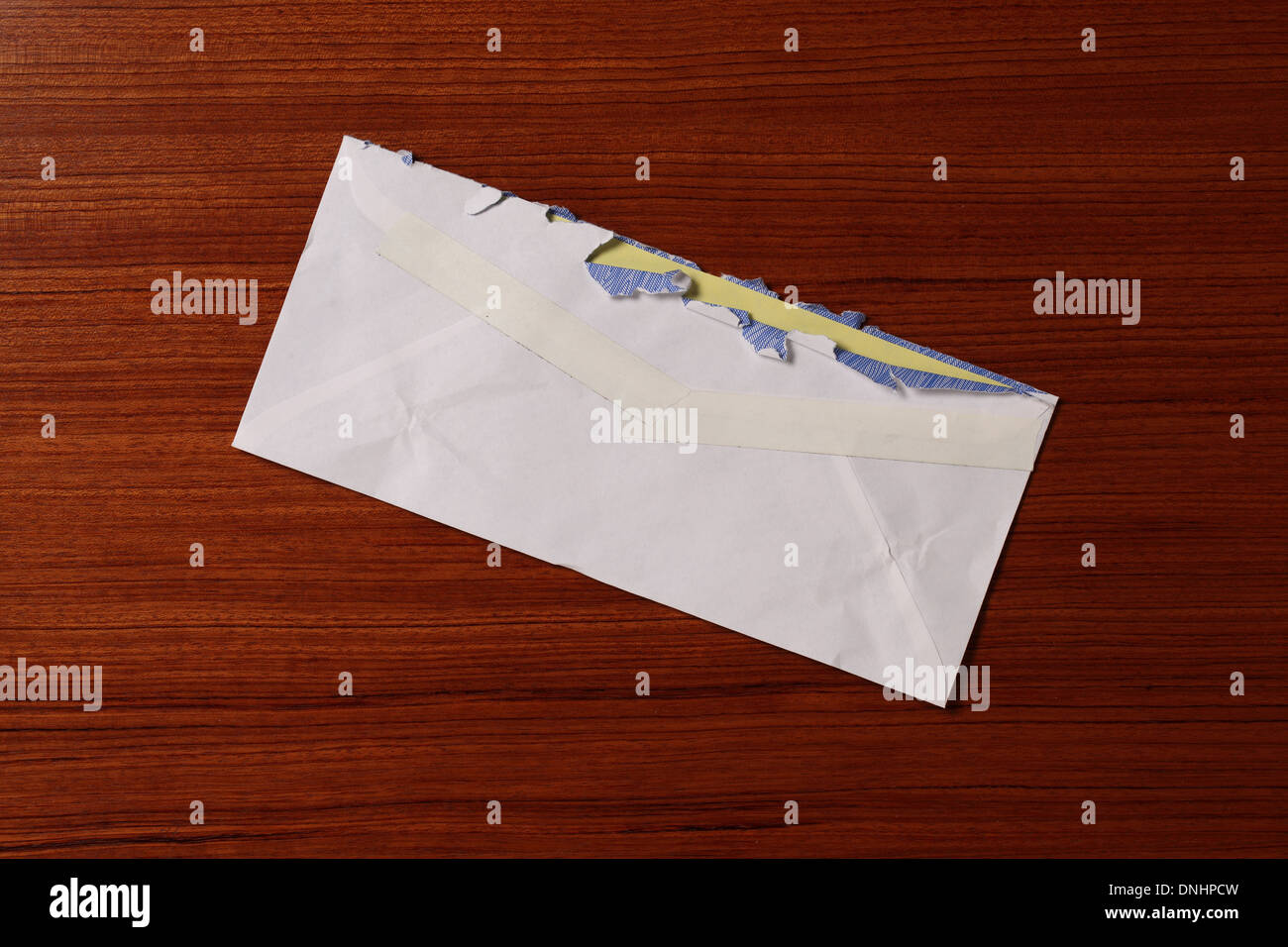 Una posta di aria della busta di affrancatura postale leggermente usurato e strappato su una superficie di legno. Foto Stock
