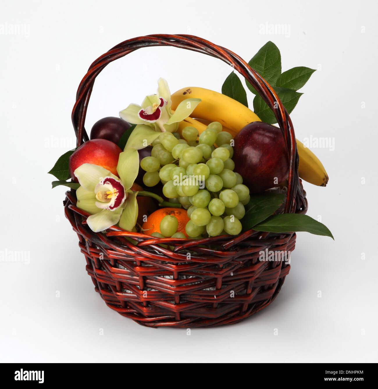 Un cesto pieno di frutta assortiti su sfondo bianco Foto Stock