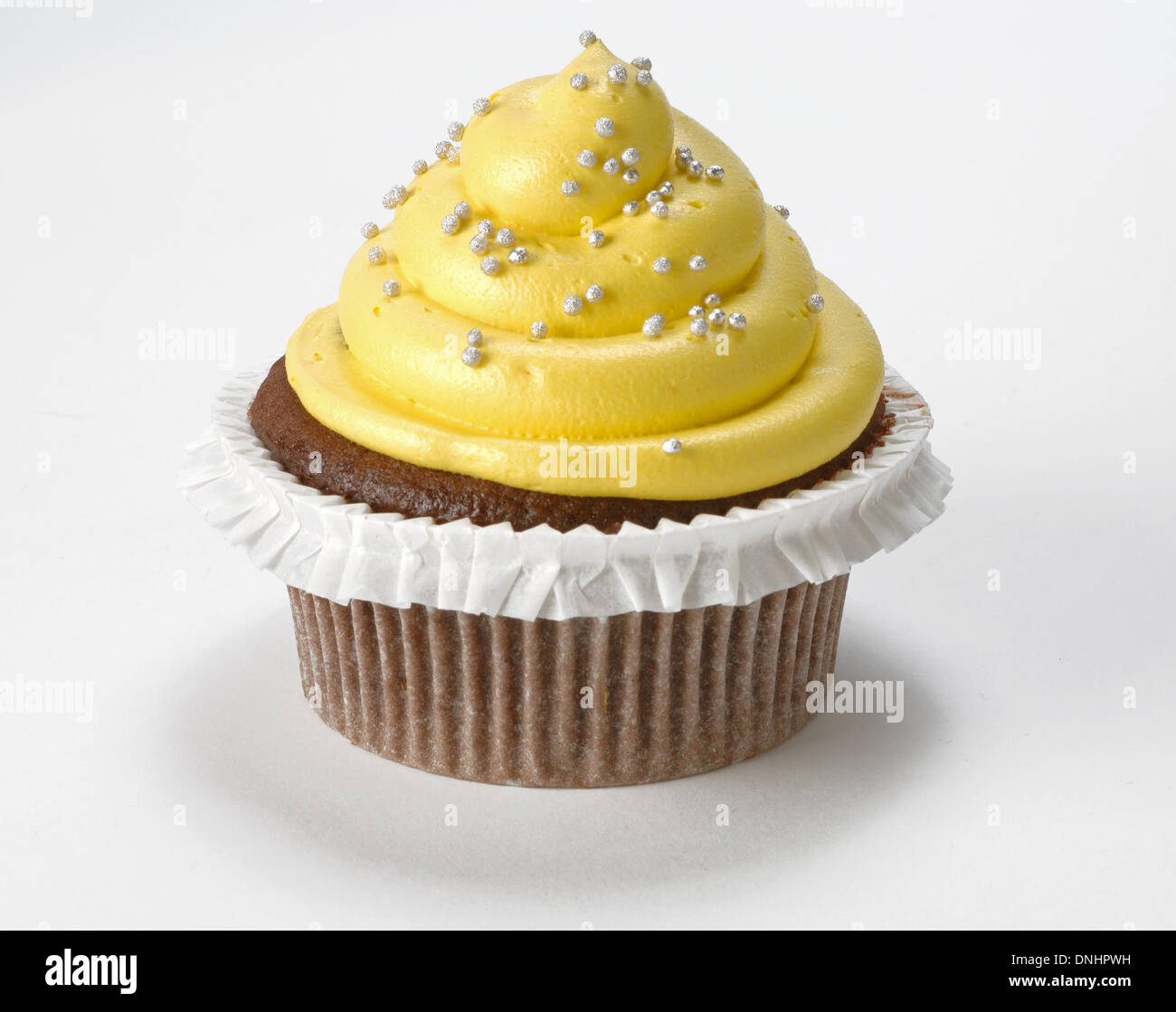 Una singola decorata cupcake giallo su sfondo bianco. Foto Stock