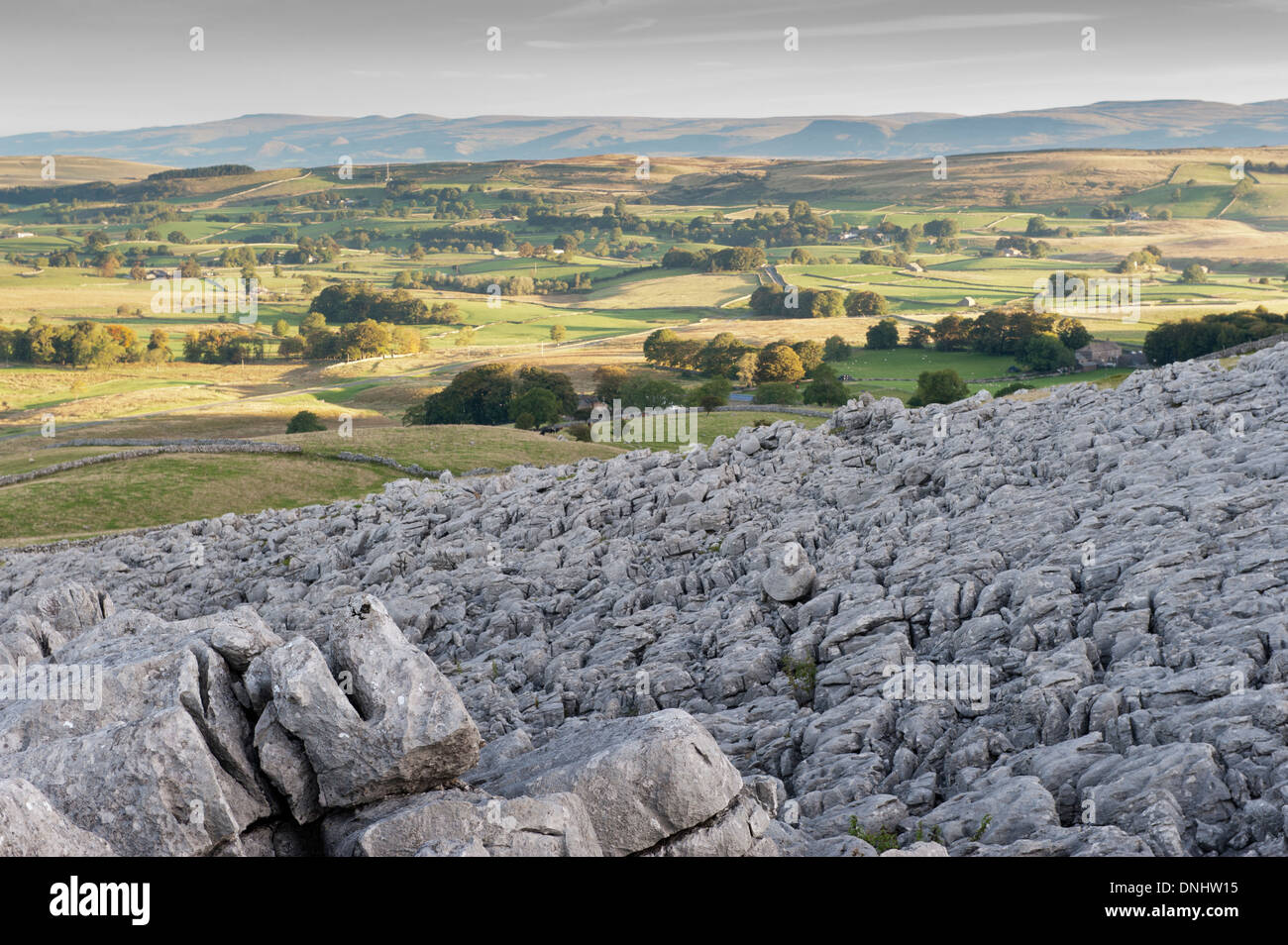 Alba sulle estremità cadde nuvole, , una zona di pavimentazione di pietra calcarea, guardando verso l'Eden Valley in Cumbria, nel Regno Unito. Foto Stock