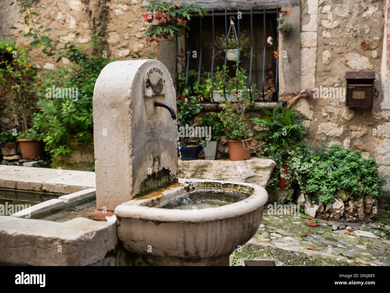 Una rustica fontana in un cortile nel villaggio di St Paul de Vence, Provenza, Francia Foto Stock