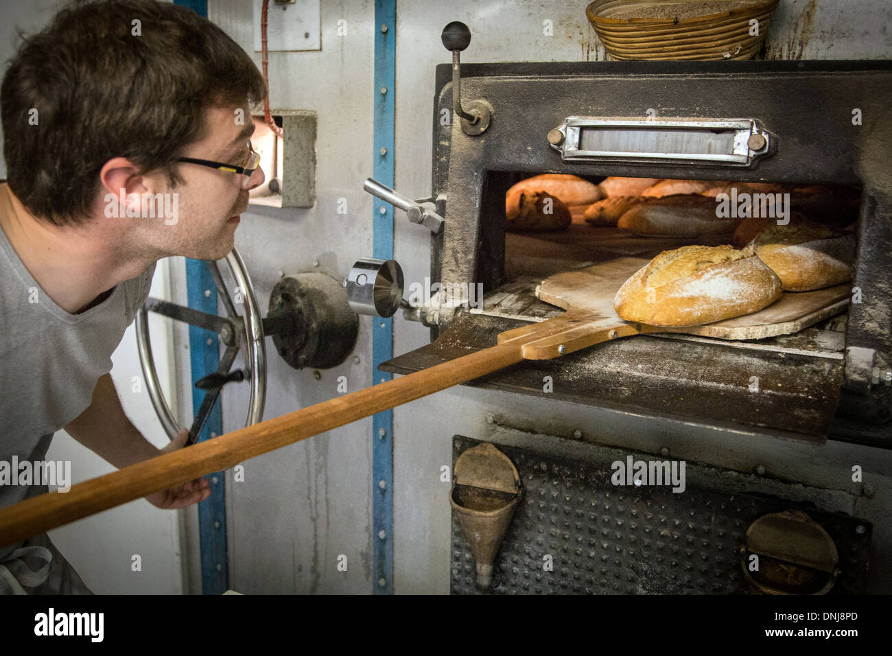 BAKER prendendo il pane dal suo forno a legna, pane organico panificio A  SAINT-MAMERT FARM, BUIS-sous-DANVILLE, Eure (27), Francia Foto stock - Alamy